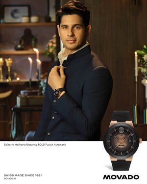 Man adjusting his jacket with a Movado watch, surrounded by decorative items.